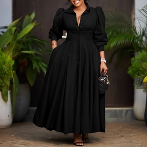Detail of elegant black long sleeve maxi dress with corset waist and full pleated skirt