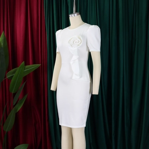 Detail of 3D floral accent and ruffle trim on elegant white fitted midi dress