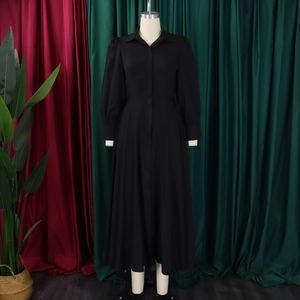 Detail of elegant black long-sleeve shirt dress with puff sleeves and button-up front design