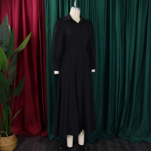 Detail of elegant black long-sleeve shirt dress with lapel collar and waist tie design