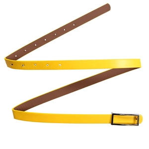 Détail d'une ceinture jaune en similicuir avec boucle classique en métal argenté et trous