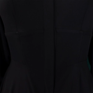 Close-up of structured waist stitching and premium black fabric on a long-sleeve dress