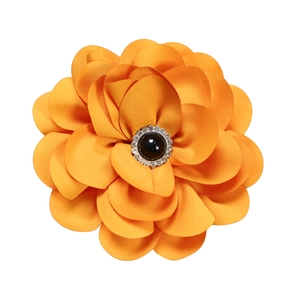 Detail of the orange fabric flower accessory with a black bead and silver gear base