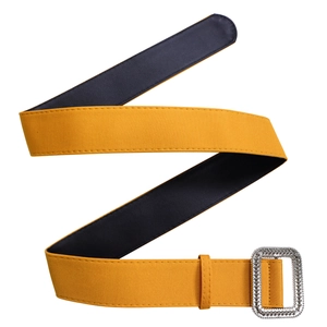 Detail of square silver textured buckle and yellow fabric strap of high waist dress belt