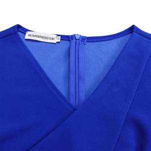 Détail d'une robe bleue à col en V montrant les coutures, la fermeture éclair et l'étiquette