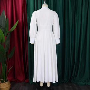 Detail of elegant white long sleeve maxi dress featuring cuffed sleeves and high waistline