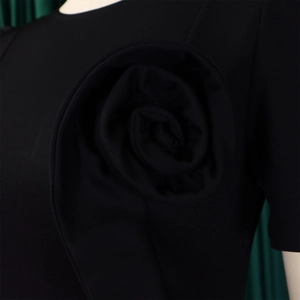 Close-up of elegant 3D floral rose applique on black short sleeve fashion dress