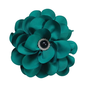 Detail of teal satin fabric flower brooch with a central black gem and rhinestones