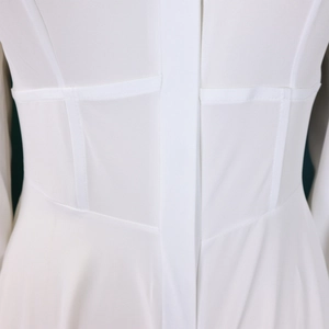 Close-up of white dress waist featuring corset-style stitching and structured seams