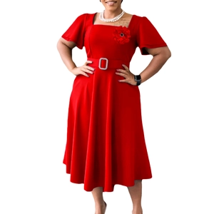 Detail of red square neck dress featuring a 3D floral accent and shimmering buckled waist belt
