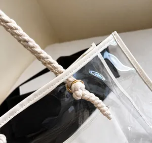 Détail d'une poignée en corde tressée blanche avec œillets métalliques dorés sur le sac