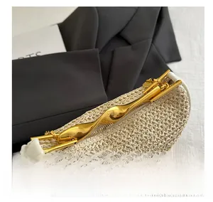 Detail of woven straw bag with unique gold metal handle and polished gold chain strap
