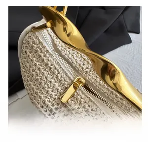 Detail of premium straw handbag featuring smooth gold zipper and polished metal handle