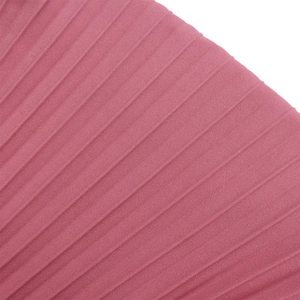 Détail macro du tissu mousseline plissé rose montrant la texture fine et le beau drapé