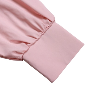 Detailed view of elegant pleated lantern sleeve cuffs on a pink maxi shirt dress