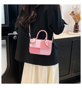 Detail of pink patchwork handbag with woven texture and silk scarf wrapped handle
