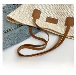 Gros plan du sac fourre-tout en paille avec anses en PU marron et étiquette de mode
