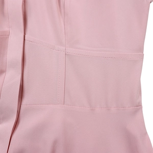 Detail shot of pink long-sleeved dress showing fabric texture and fine stitching craftsmanship