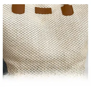 Détail de la texture tressée du sac fourre-tout beige avec empiècement en cuir brun