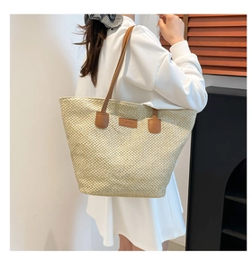 Gros plan d'un sac cabas en paille avec poignées en cuir marron et étiquette 'FASHION'