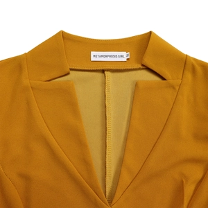 Détail du col en V avec étiquette taille M sur une robe jaune moutarde à taille haute