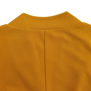 Détail de la couture du col en V et du tissu texturé jaune gingembre de la robe