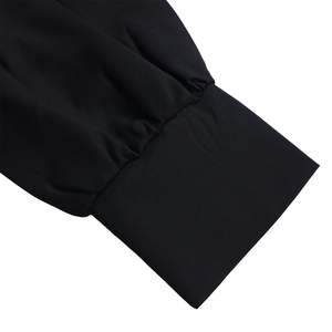 Detailed close-up of pleated cuff design and high-density stitching on a long sleeve dress