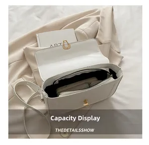 Détail de la capacité intérieure du sac bandoulière en cuir blanc avec serrure dorée