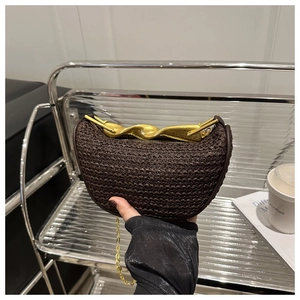 Detail of dark brown woven crescent bag with unique gold twisted metal handle and chain