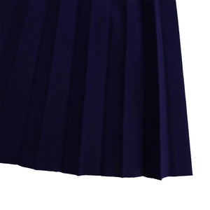 Gros plan détaillé sur la texture du tissu plissé bleu marine de cette robe à col en V