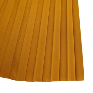 Détail macro du tissu jaune moutarde plissé avec une fine texture en accordéon