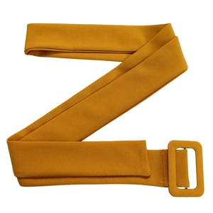 Détail d'une large ceinture en tissu jaune moutarde avec boucle rectangulaire gainée