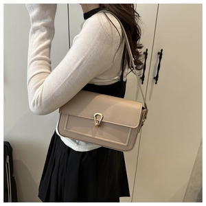Détail du sac à bandoulière beige à grain de litchi avec boucle métallique dorée en fer à cheval