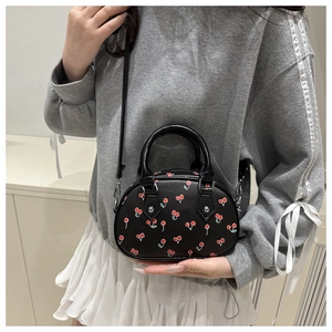 Detail of black cherry print tote bag featuring smooth faux leather and silver metal hooks