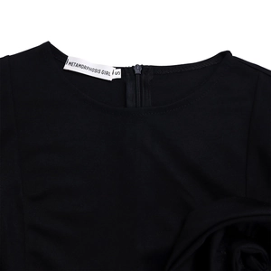 Detailed view of back neckline featuring invisible zipper and brand label on black dress