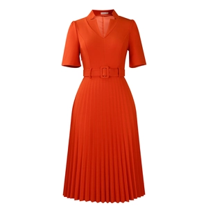 Détail d'une robe plissée orange avec col en V, manches courtes et une ceinture assortie
