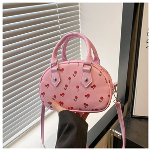 Detailansicht der rosa Mini-Handtasche mit Kirschmuster und passenden Tragegriffen