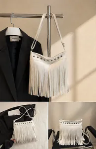 Primer plano de bolso blanco con tachuelas metálicas y flecos largos decorativos
