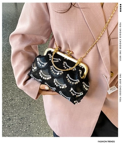 Dettaglio di pochette da sera nera vintage con ricamo di paillettes e cornice oro
