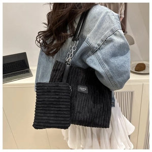 Detail of black corduroy tote bag with chain strap and matching small pouch for commuting