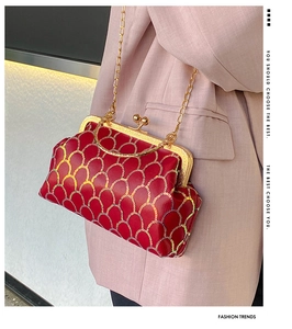 Detail van rode pailletten crossbodytas met gouden handvat voor avondkleding
