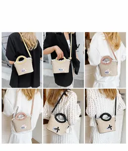 Detail of straw woven bucket bag featuring delicate white lace trim and colorful PU handles