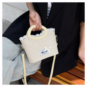 Detail of woven straw bag featuring white lace trim and a delicate bow decoration
