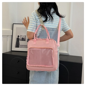 Rear view of a pink nylon ita bag with a clear window shown on a casual model