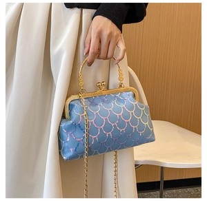 Detail of blue iridescent sequin evening bag with gold handle and heart closure