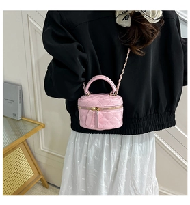 Detailansicht einer rosa gesteppten Mini-Zylindertasche mit Goldkette und Tragegriff