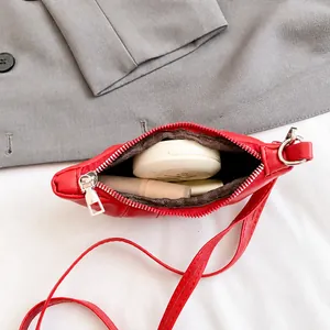 Macro view of red mini leather bag interior showing space for lipstick and makeup powder