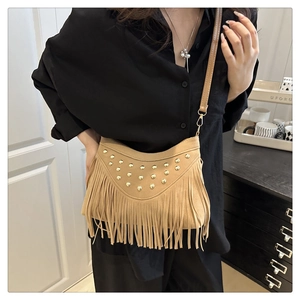 Detail of rivet small square bag with long tassels and adjustable strap shown on model