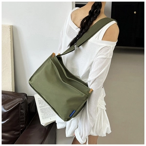 Close-up of army green messenger bag with adjustable strap and side buckle detail