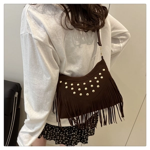 Detailed back view of a dark brown tassel shoulder bag with golden studs on soft suede